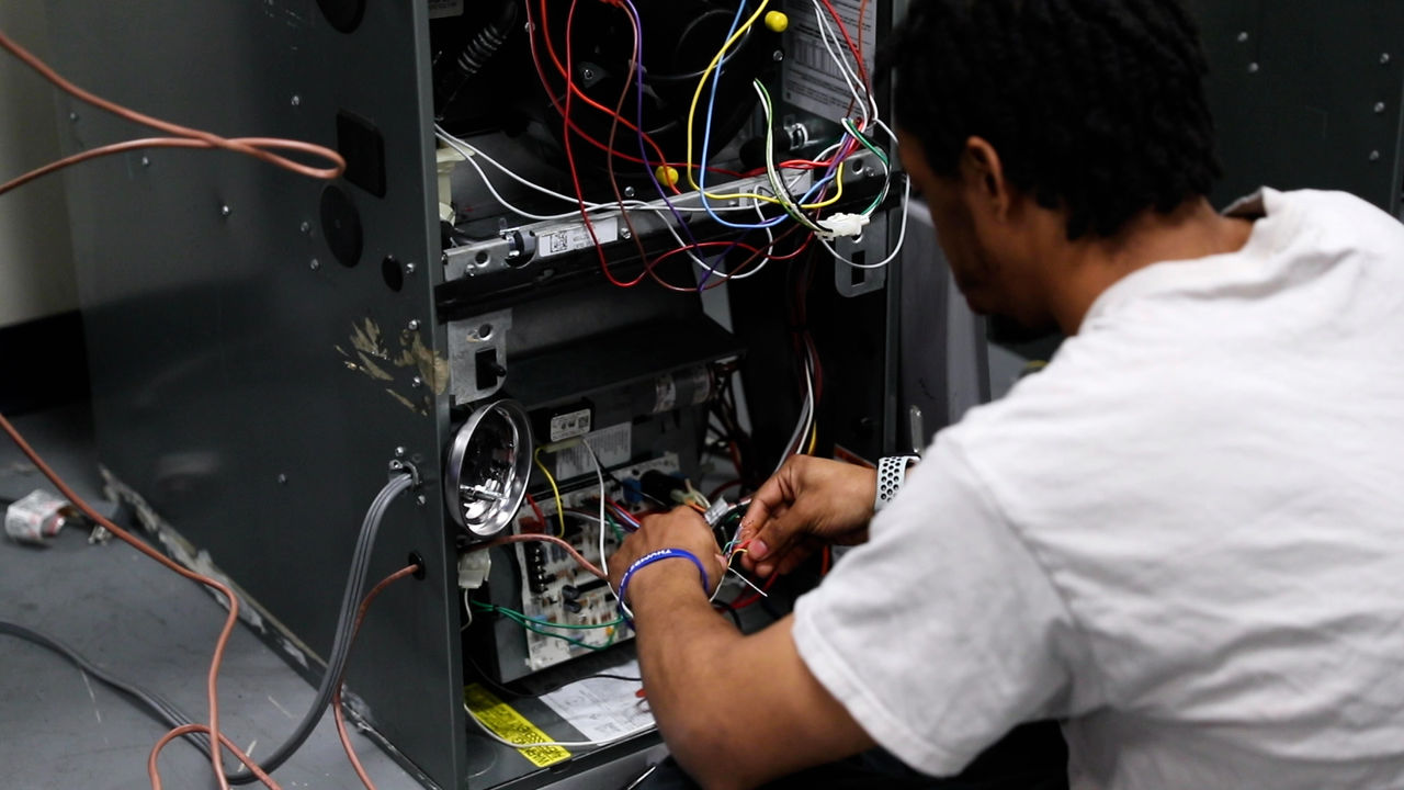 Technician repairing electrical components inside machine