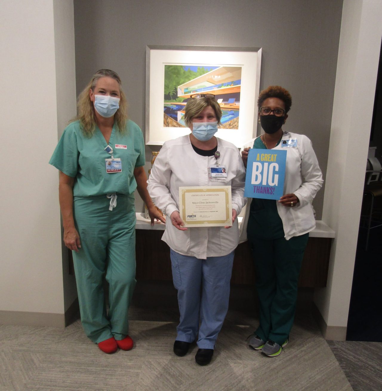 Healthcare workers holding certificate and thank-you sign
