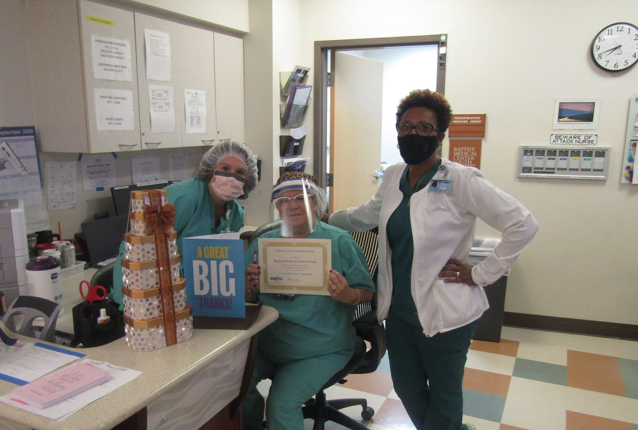 Healthcare staff celebrating with certificate and gifts